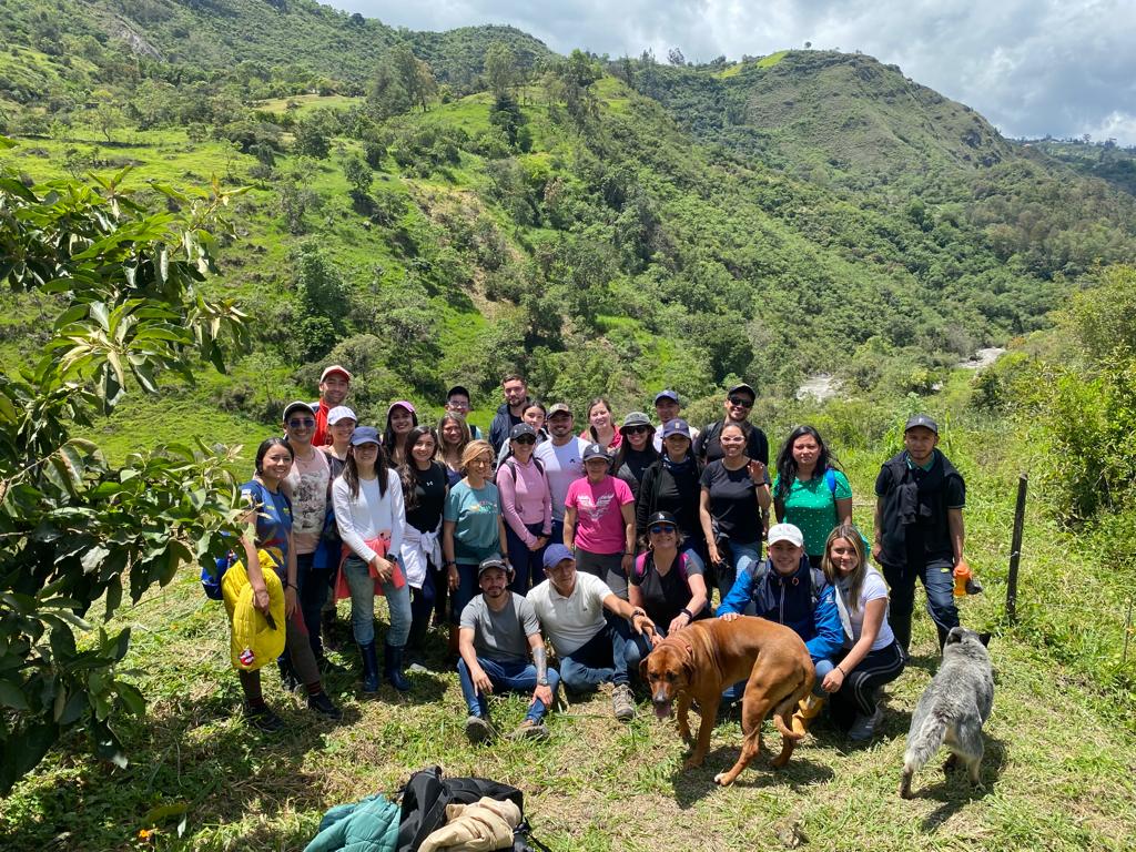 Colaboradores de la compañía posando frente al lugar de la jornada de siembra